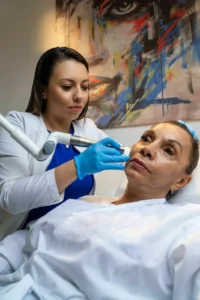 Dra. Carolina Rivera Bedoya realizando un tratamiento facial a una paciente